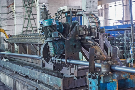 Industrial worker cutting and welding metal. Rolling mill machine.