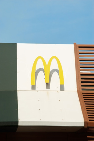 Krivoy Rog, Ukraine - April 7, 2016: McDonalds sign against blue sky. The McDonald's Corporation is the world's largest chain of hamburger fast food restaurants.のeditorial素材