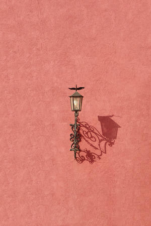 Old vintage iron lantern against the red grunge wallの写真素材