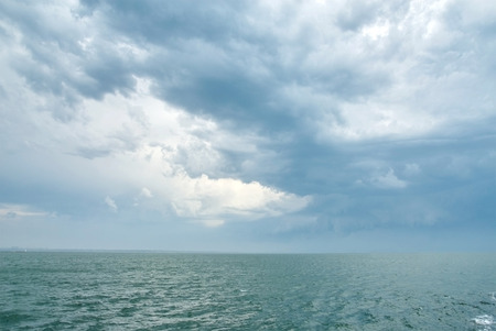Dramatic dark cloudy sky over sea. Natural photo backgroundの写真素材