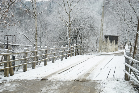 Wooden bridge through frozen river. Winter landscapeの写真素材