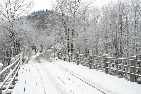 Wooden bridge through frozen river. Winter landscapeの写真素材