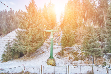 Ski lift with seats going over the coniferous forest and mountain. Sunny dayの写真素材
