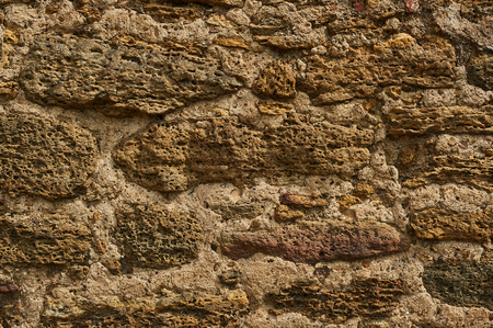 Ancient stone wall. Yellow grunge texture of old brick.の写真素材