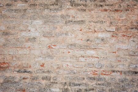 Old brick wall texture with scratches and crack. Ancient stone wall. Yellow grunge texture of old brickの写真素材