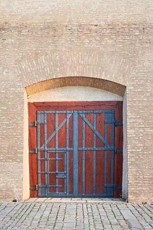 Old abtique wooden gate and old brick wall. Close gate.の写真素材