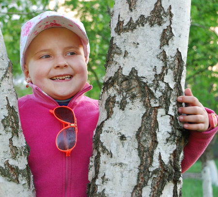 Smiling pretty kid between treesの写真素材