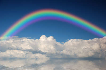 White fluffy clouds wih rainbow in blue skyの写真素材