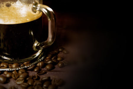Cup of coffee and scattered grains on a blurred backgroundの写真素材
