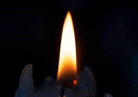 Just a burning candle in the dark.の写真素材