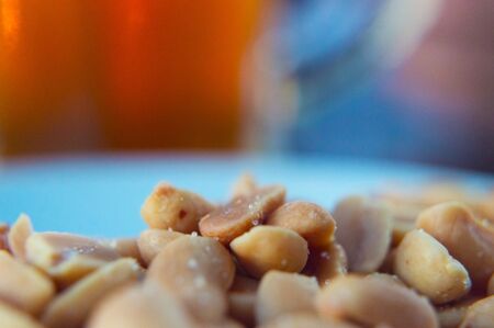 Nuts with salt close up on a blurred beer backgroundの写真素材