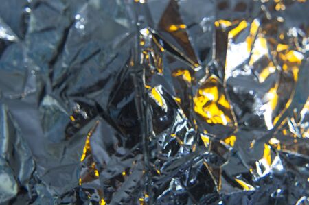 Background of crumpled foil with reflections of lightの写真素材