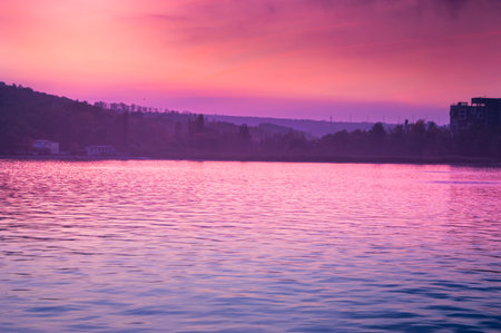 Red reflection of the sun in the lake water at sunset