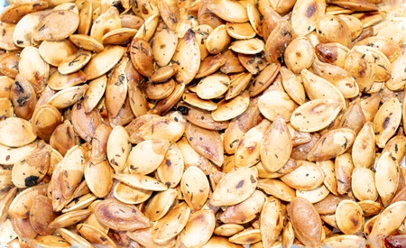 Roasted and crispy pumpkin seeds in herbs and spicesの写真素材