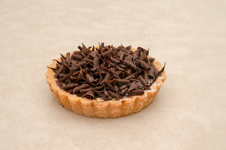 Side-view of an individual chocolate tart isolated on a light backgroundの写真素材