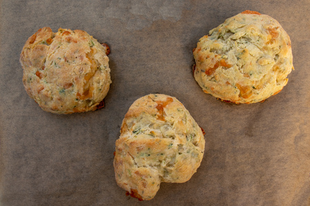 Freshly cooked cheese scones isolated on greece-proof paper.の写真素材