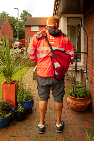 Beverley, England, - 06,12, 2019: A British Royal Mail postman making a delivery to a residential propertyのeditorial素材