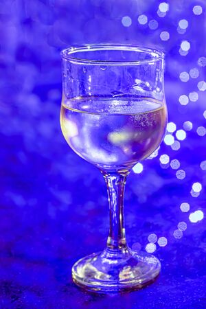 A glass of chilled white wine against a blue backgroundの写真素材