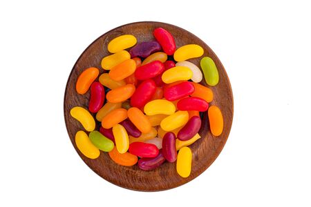 A small wooden dish full of jelly sweets isolated on a white backgroundの写真素材