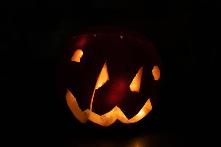 An large creepy illuminated jack o lantern against a dark backgroundの写真素材