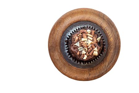 top down view of a decorated chocolate bun on a wooden plate and isolated on a white backgroundの写真素材