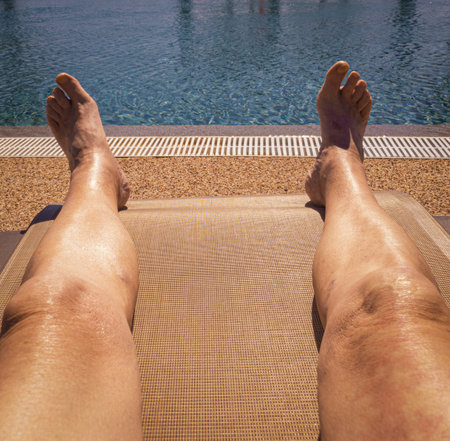 overhead view of an old man relaxing on a sun bed whilst on holidayの写真素材