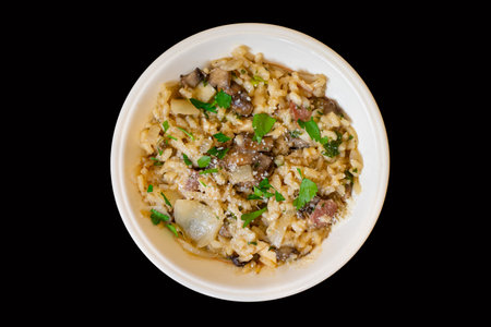 Top down view of t chicken and mushroom risotto isolated on a black backgroundの写真素材