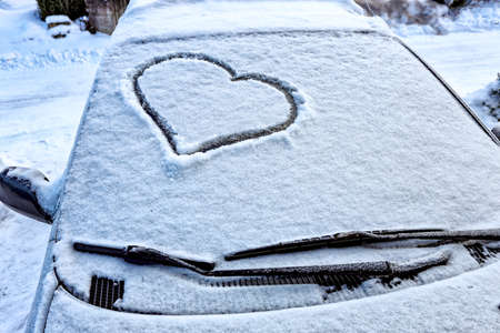Frozen windshield in the snow with a heartの写真素材