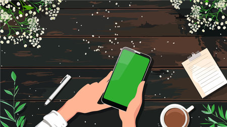Hand Holding a Smartphone with Green Screen Display on Wooden Table
