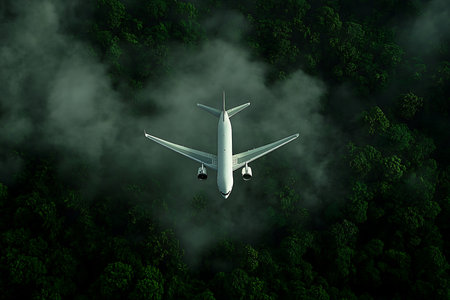 A commercial jetliner soars through a cloudy sky from an aerial perspective. The aircraft is positioned above a dimly lit, dense forest, creating a dramatic and atmospheric scene.の素材