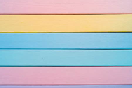 A soothing backdrop featuring horizontal planks in soft pastel shades of pink, yellow, and blue. Ideal for creating a gentle, calming, or whimsical atmosphere.の素材