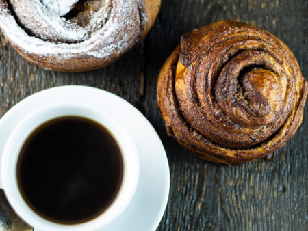 Cup of coffee and sweet buns on a rough wooden backgroundの写真素材