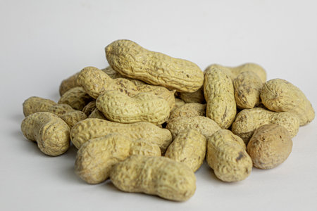 Handful of the raw peanuts on white background