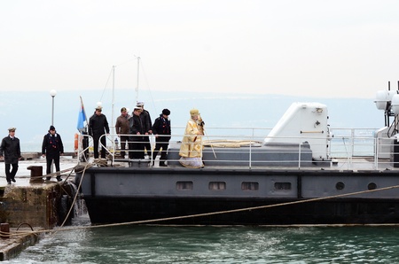 VARNA, BULGARIA - JANUARY 6: The priest is about to release the wooden cross in to the freezing waters of the Black Sea. Eastern Orthodox Church honors Epiphany on January 6, 2011 in Varna, Bulgaria のeditorial素材