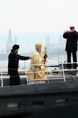 VARNA, BULGARIA - JANUARY 6: The priest is about to release the wooden cross in to the freezing waters of the Black Sea. Eastern Orthodox Church honors Epiphany on January 6, 2011 in Varna, Bulgaria のeditorial素材