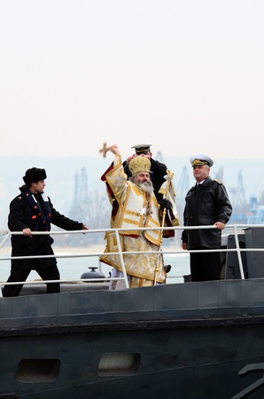 VARNA, BULGARIA - JANUARY 6: The priest is about to release the wooden cross in to the freezing waters of the Black Sea. Eastern Orthodox Church honors Epiphany on January 6, 2011 in Varna, Bulgaria のeditorial素材