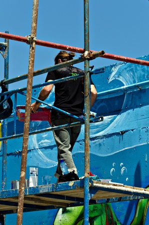 VARNA, BULGARIA - JUNE 2: Graffiti artist on a scaffolding at the "Creatures from Black Sea" Sprite Graffiti Jam 2011 in Port of Varna, on June 2, 2011 in Varna, Bulgaria. のeditorial素材