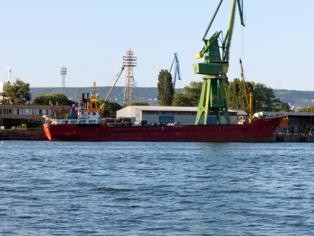 VARNA, BULGARIA - JULY 21: Cargo ship MUAZZEZ K, Flag: Turkey, Year Built: 1995, is loaded with goods on July 21, 2012 in Varna, Bulgaria.のeditorial素材