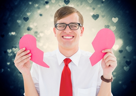 Crying man holding broken heart with heart shapes on backgroundの写真素材
