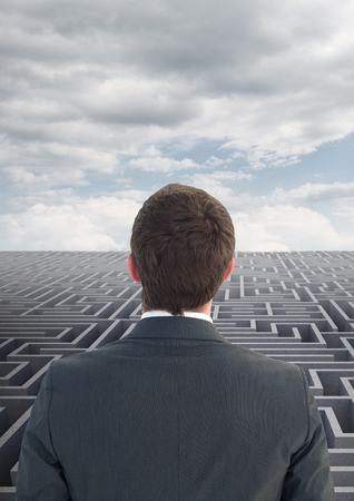 Composite images of rear view of a business man looking over mazeの写真素材
