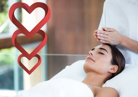 Composite image of woman getting spa treatment with heart shapesの写真素材