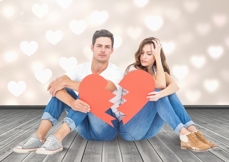 Composite image of sad couple holding broken heartの写真素材