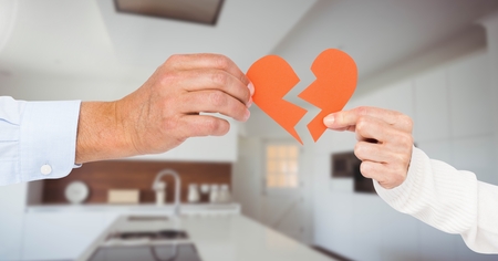 Composite image of hands holding a broken heart against blur boardroom in backgroundの写真素材