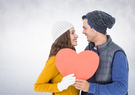Romantic couple holding a heart against white backgroundの写真素材