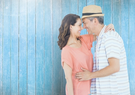 Romantic couple standing against blue wooden backgroundの写真素材
