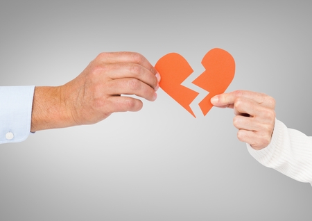 Close-up of couple hands holding a broken heartの写真素材