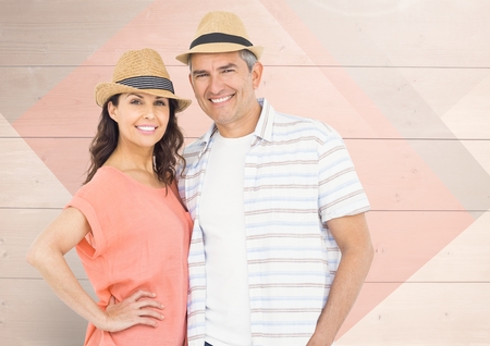 Mature couple standing and smiling against wooden backgroundの写真素材