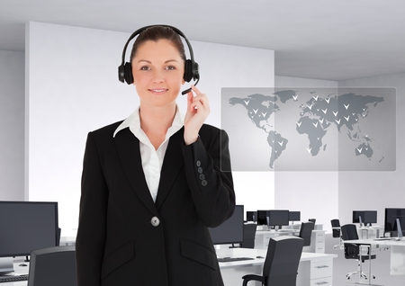 Portrait of smiling businesswoman with headset in office against digitally generated backgroundの写真素材