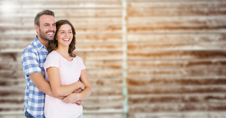 Composite image of happy couple embracing each other against blur brick backgroundの写真素材