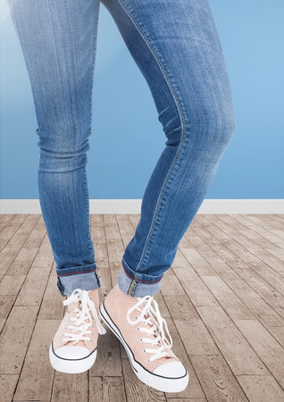 Low section of woman standing on wooden jetty against blue backgroundの写真素材